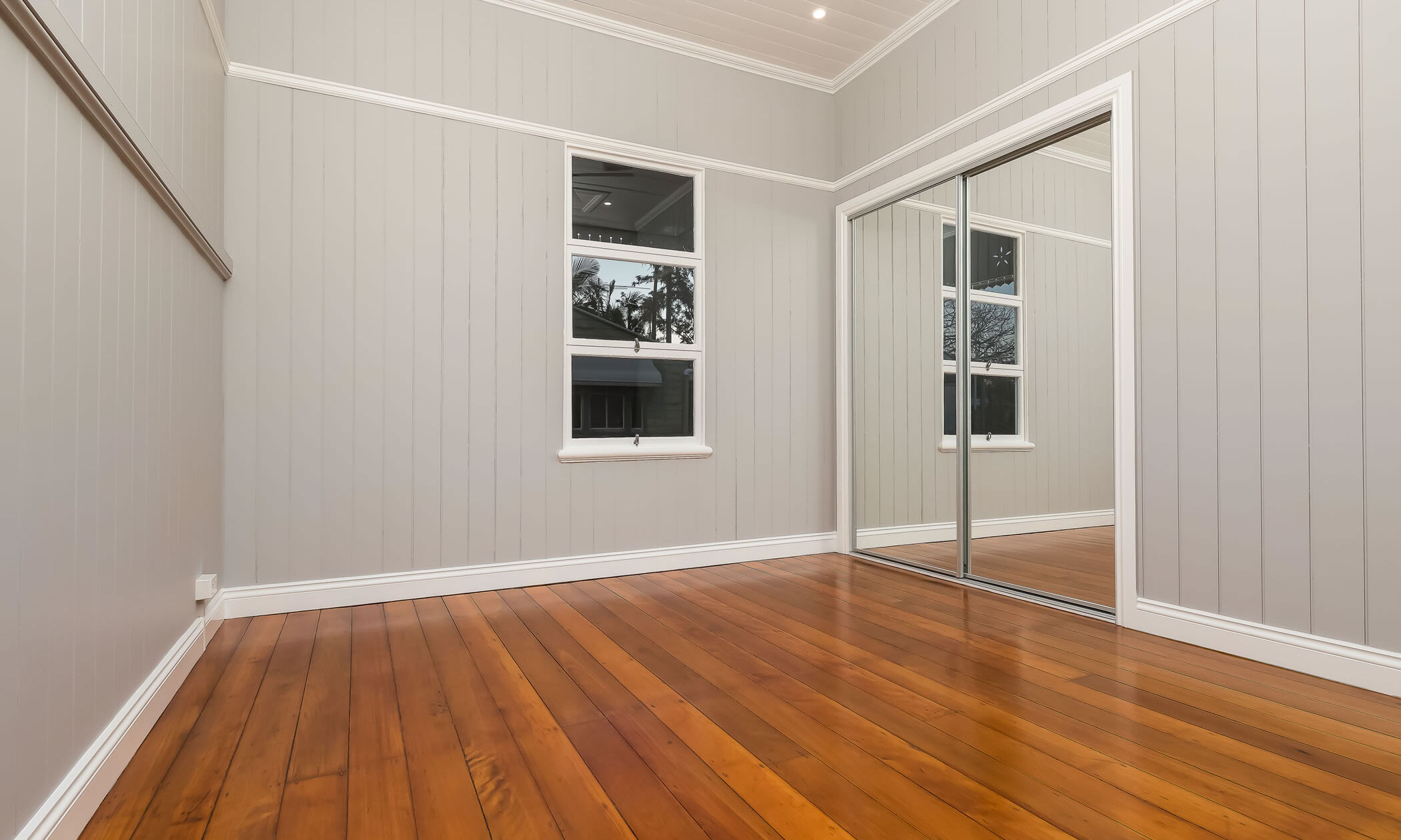 Bedroom with VJ wall paneling in bedroom with pine flooring in house renovation in Woolloongabba 