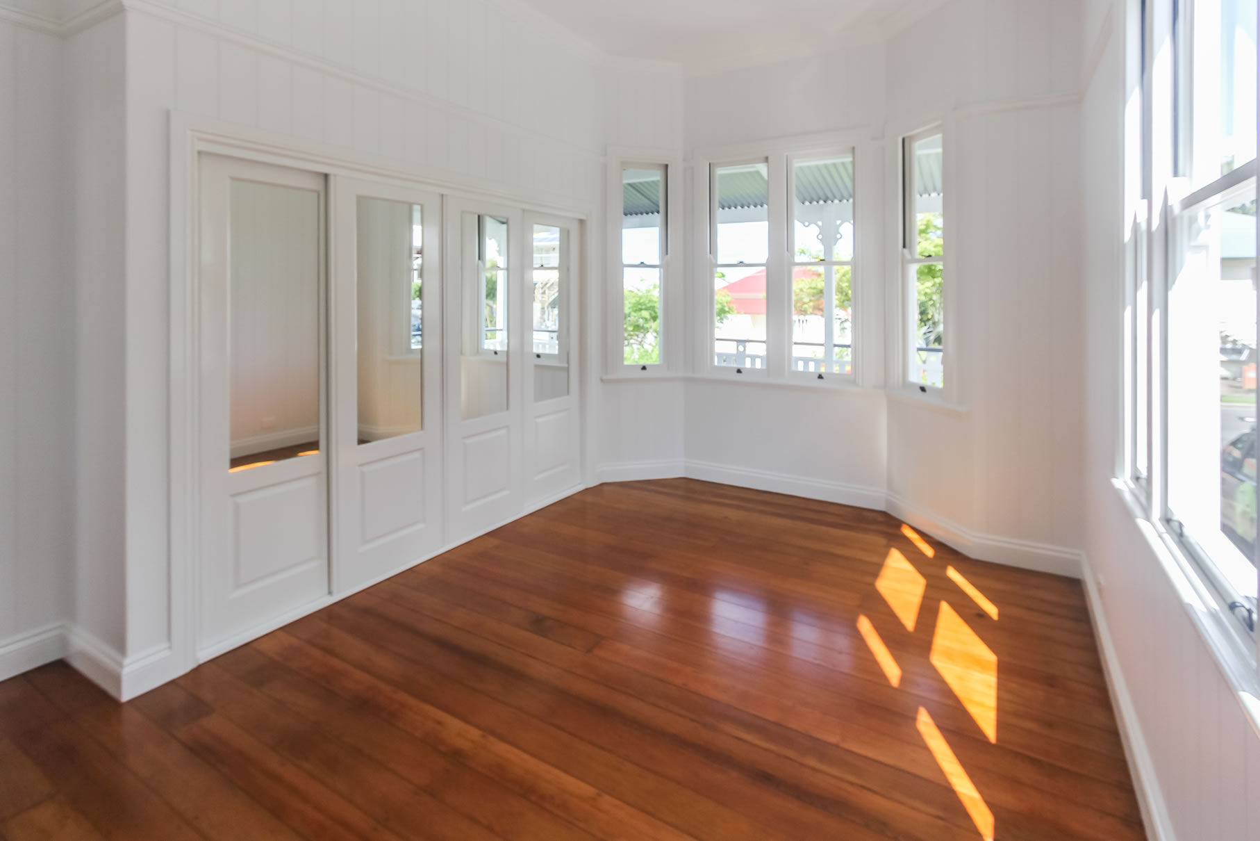 Bay window and traditional mirrored robe doors in master bedroom