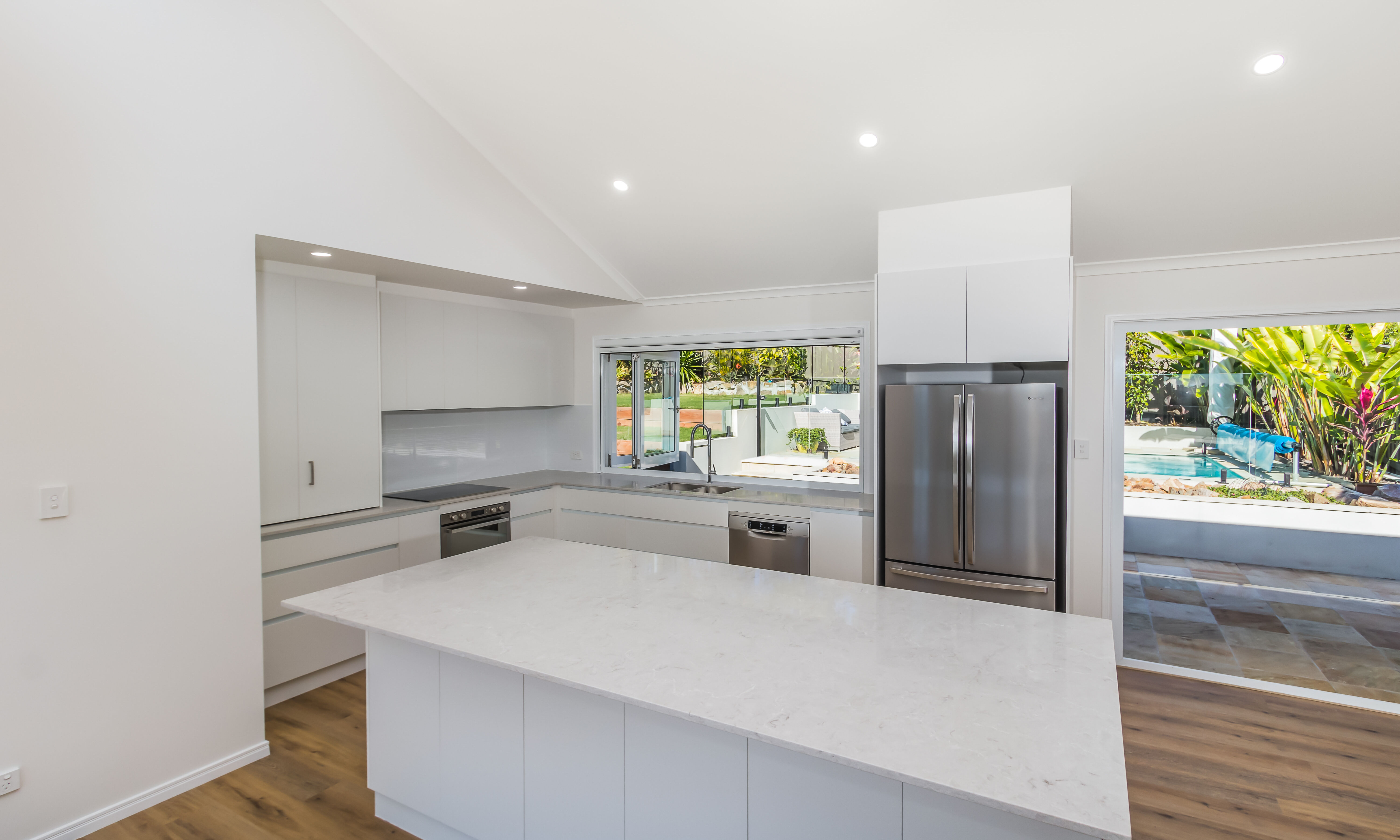 Kitchen with stone tops and finger pull cabinetry-travertine tiles