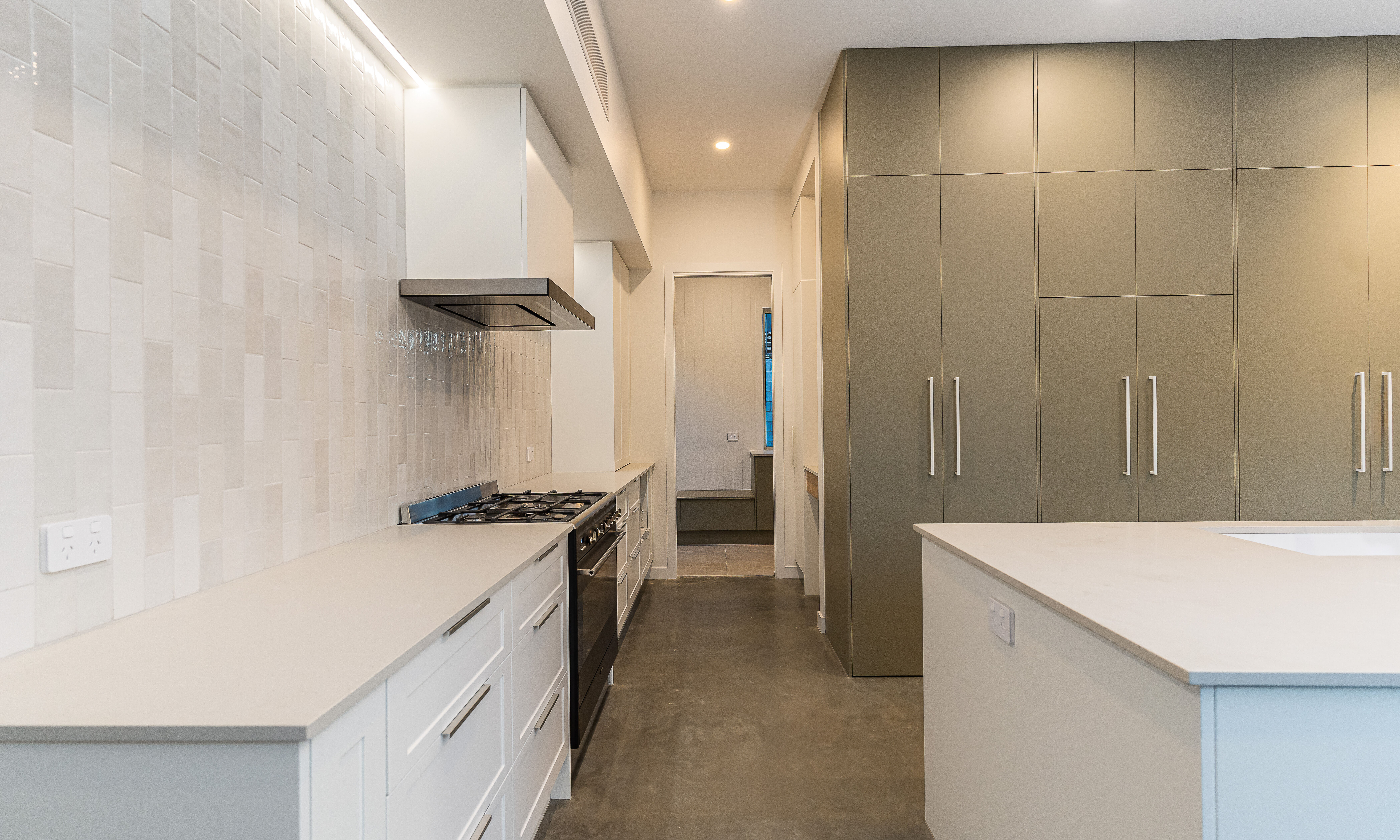 white kitchen-subway tiles-polished floors-stone benchtop