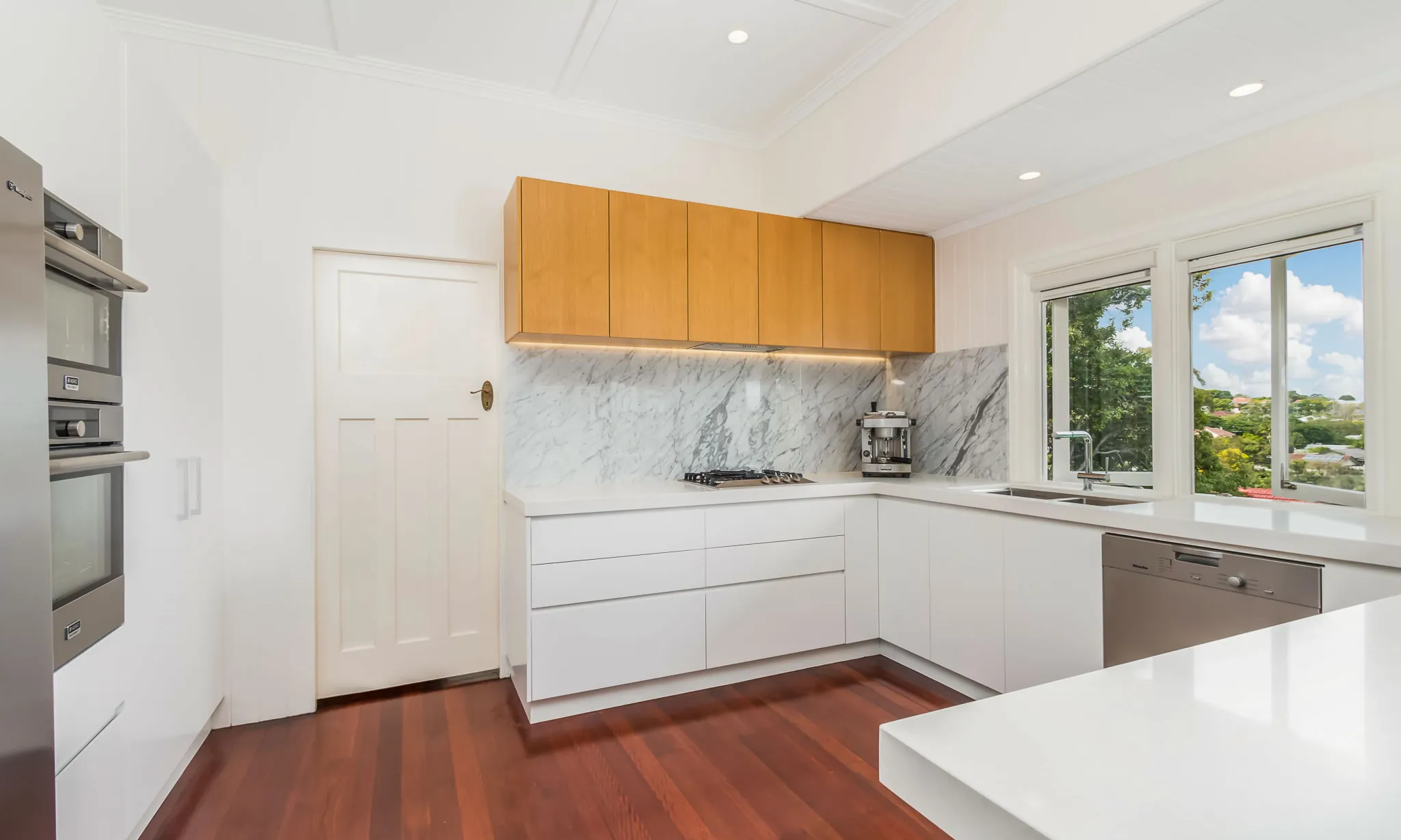 kitchen-marble splashback-white cabinetry-timber floors