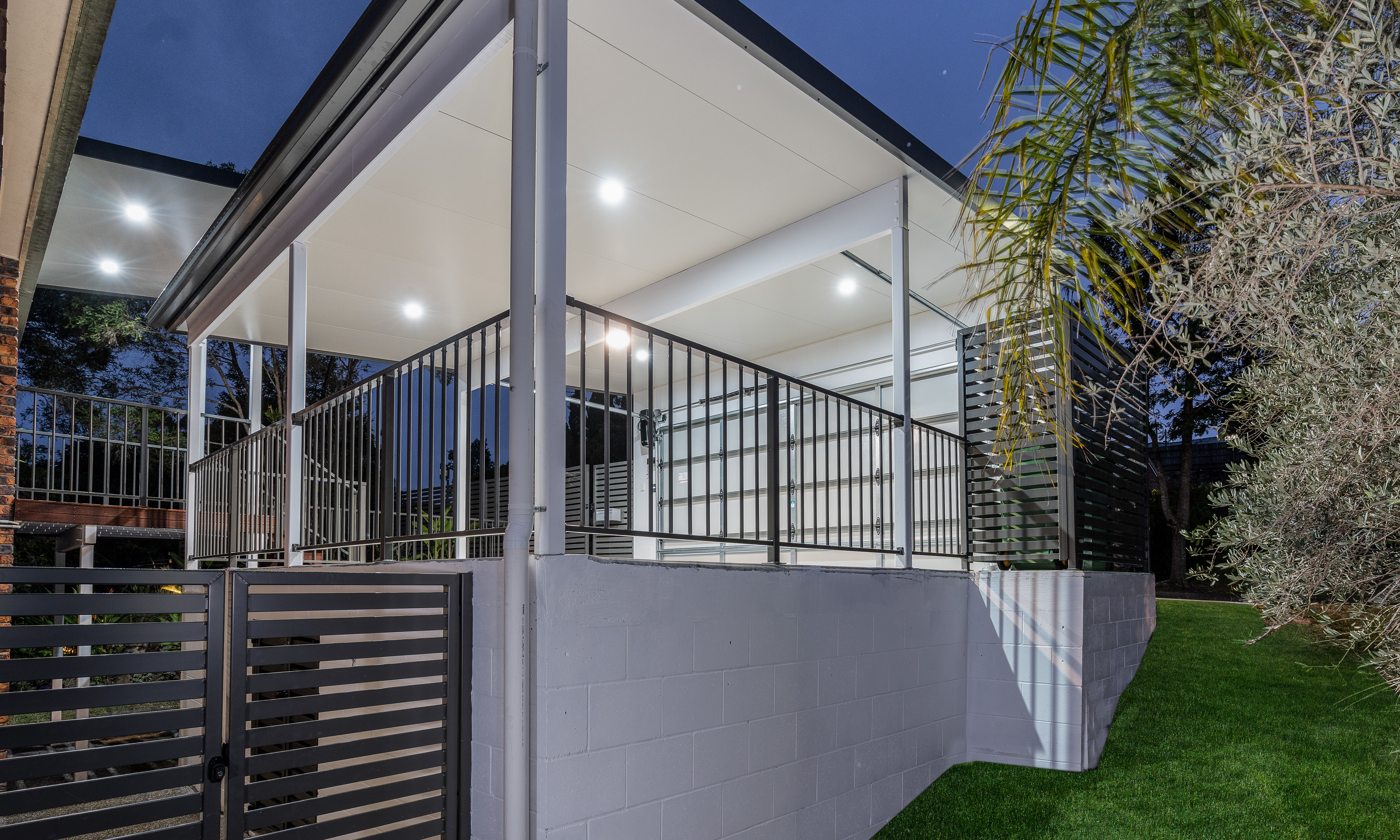 Carport with garage door and balustrade with powder coated gate