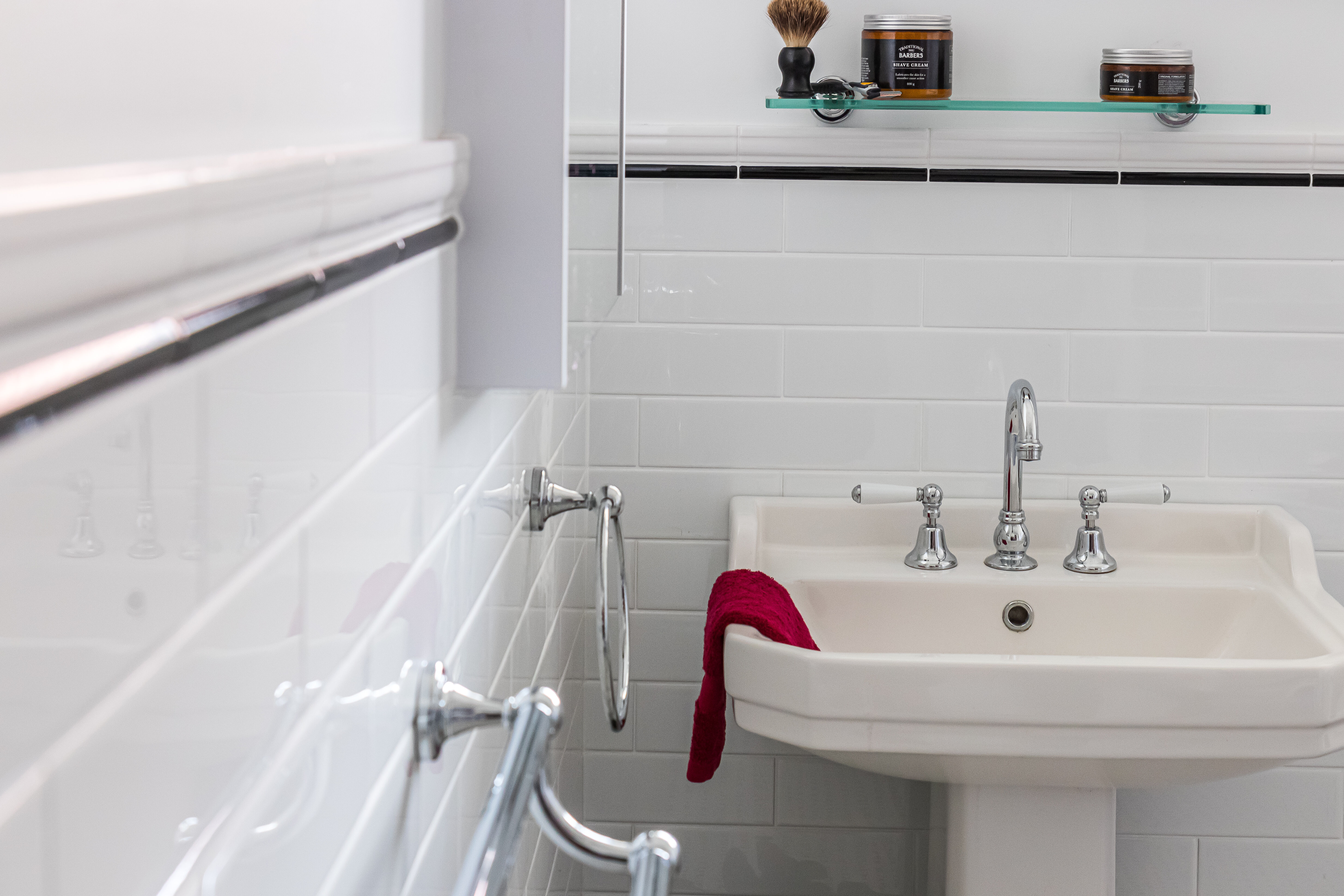 Pedestal Basin, chrome tapware and black and white tiles in bathroom