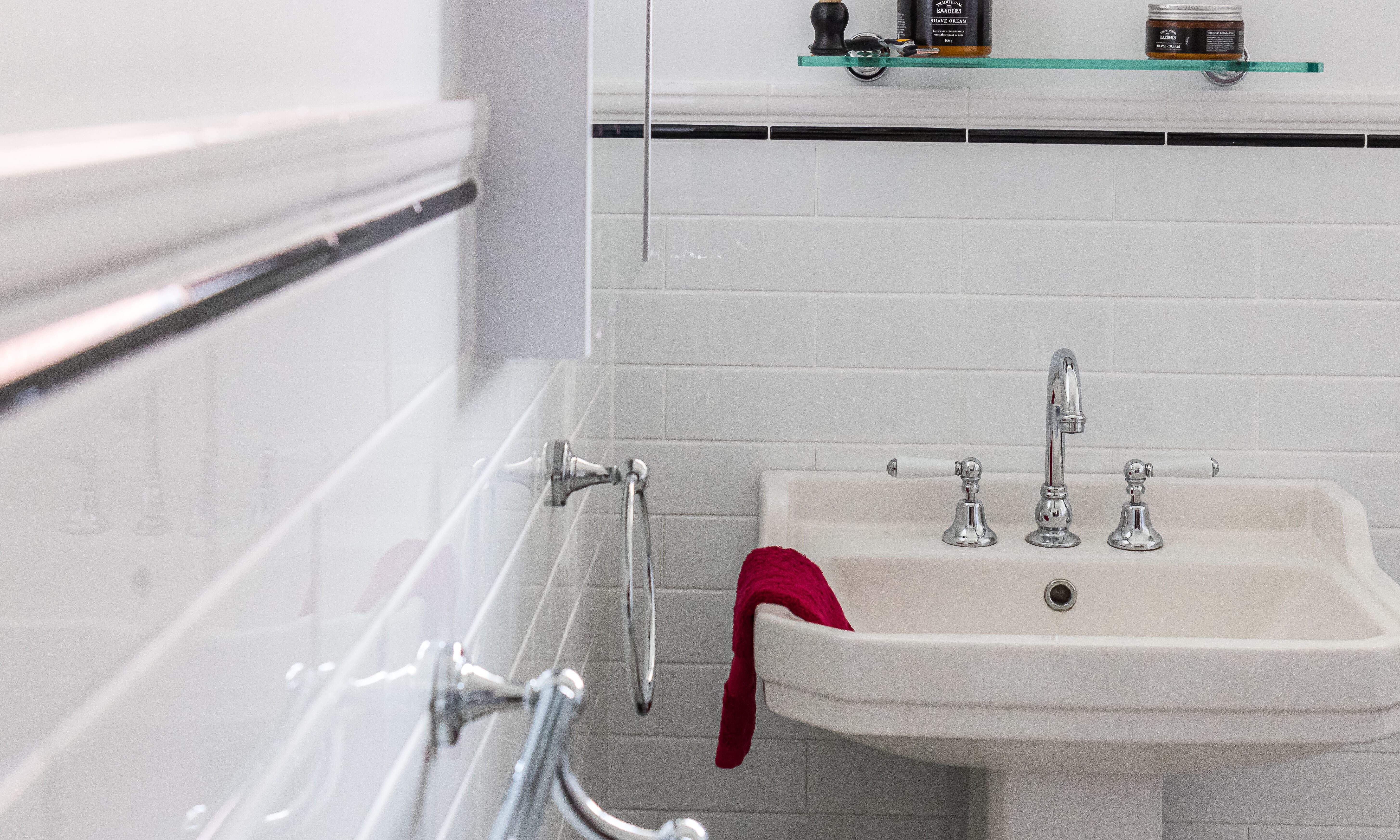 Pedestal Basin, chrome tapware and black and white tiles in bathroom