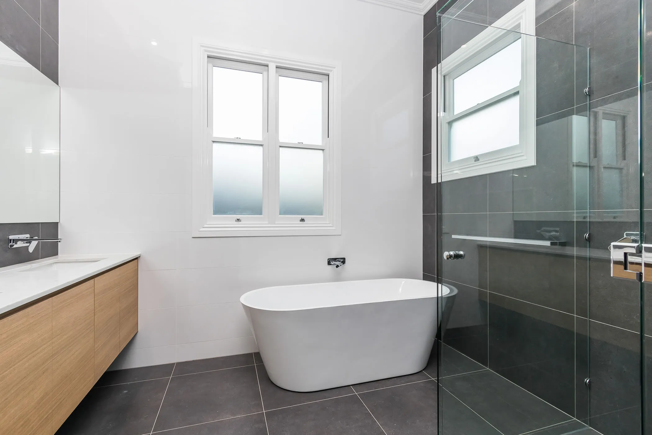 Bathroom with freestanding bath and frameless shower screen