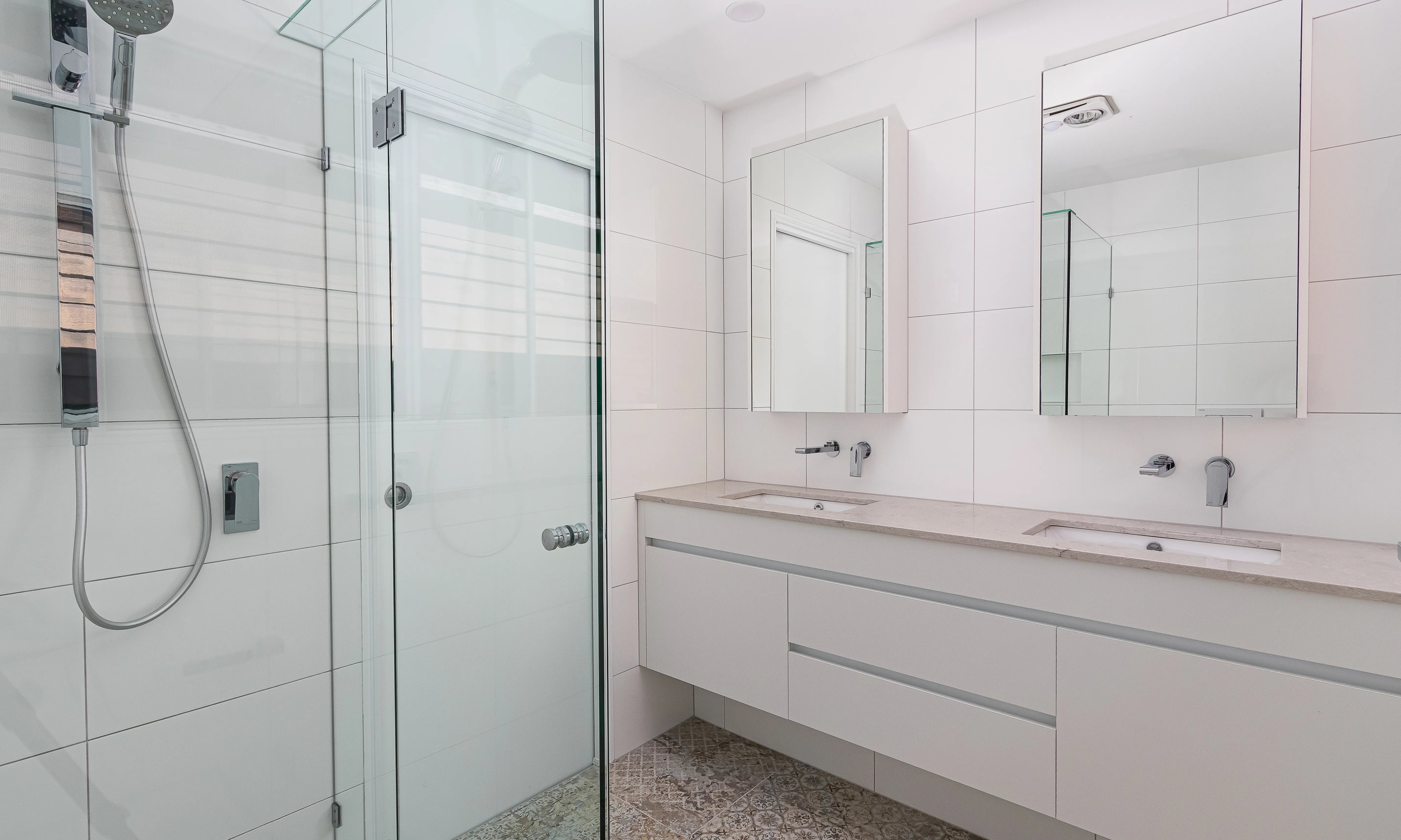 Ensuite with floating vanity, mirrored shaving cabinets and fixed glass shower screen