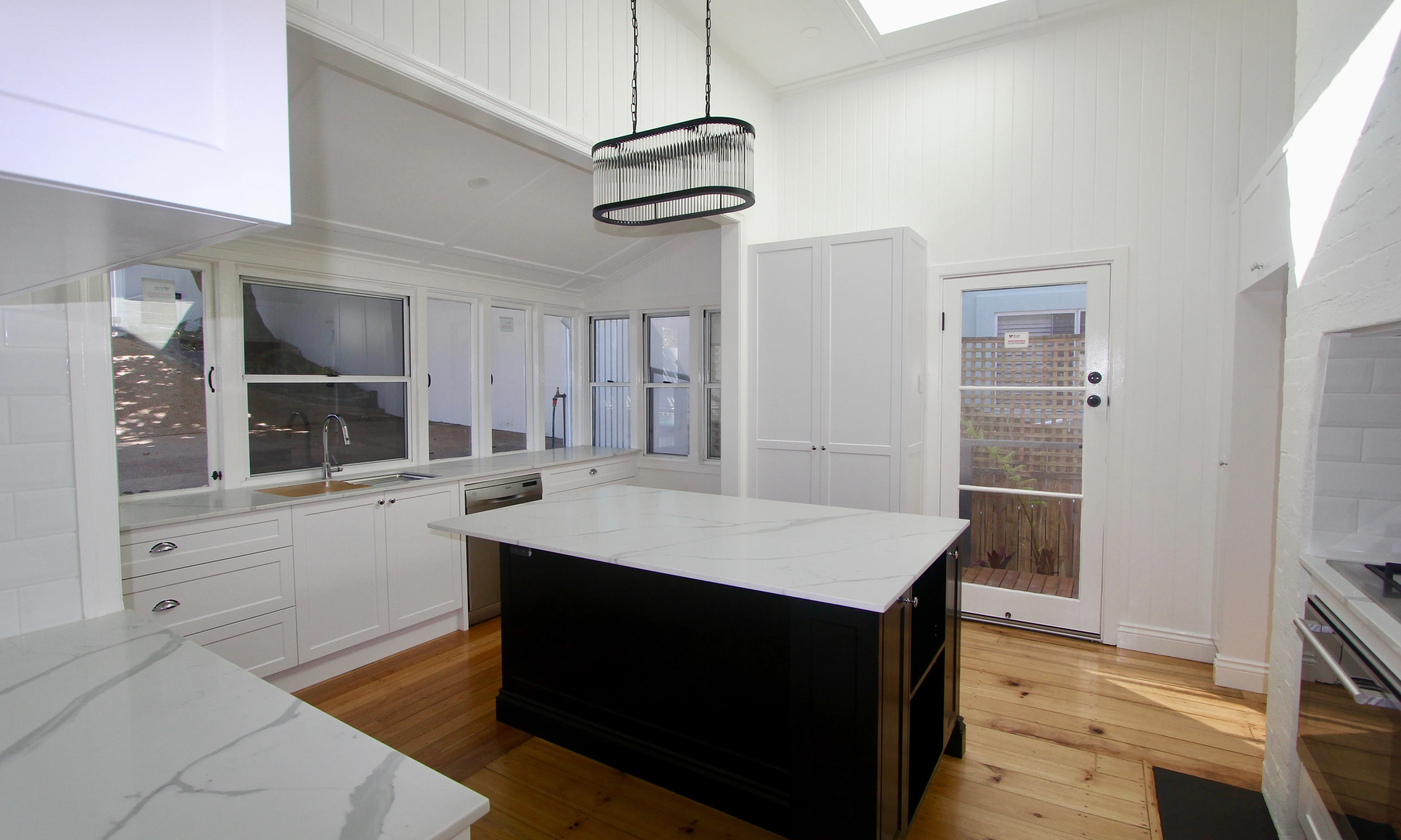 Black and white kitchen with marble top and pendant light