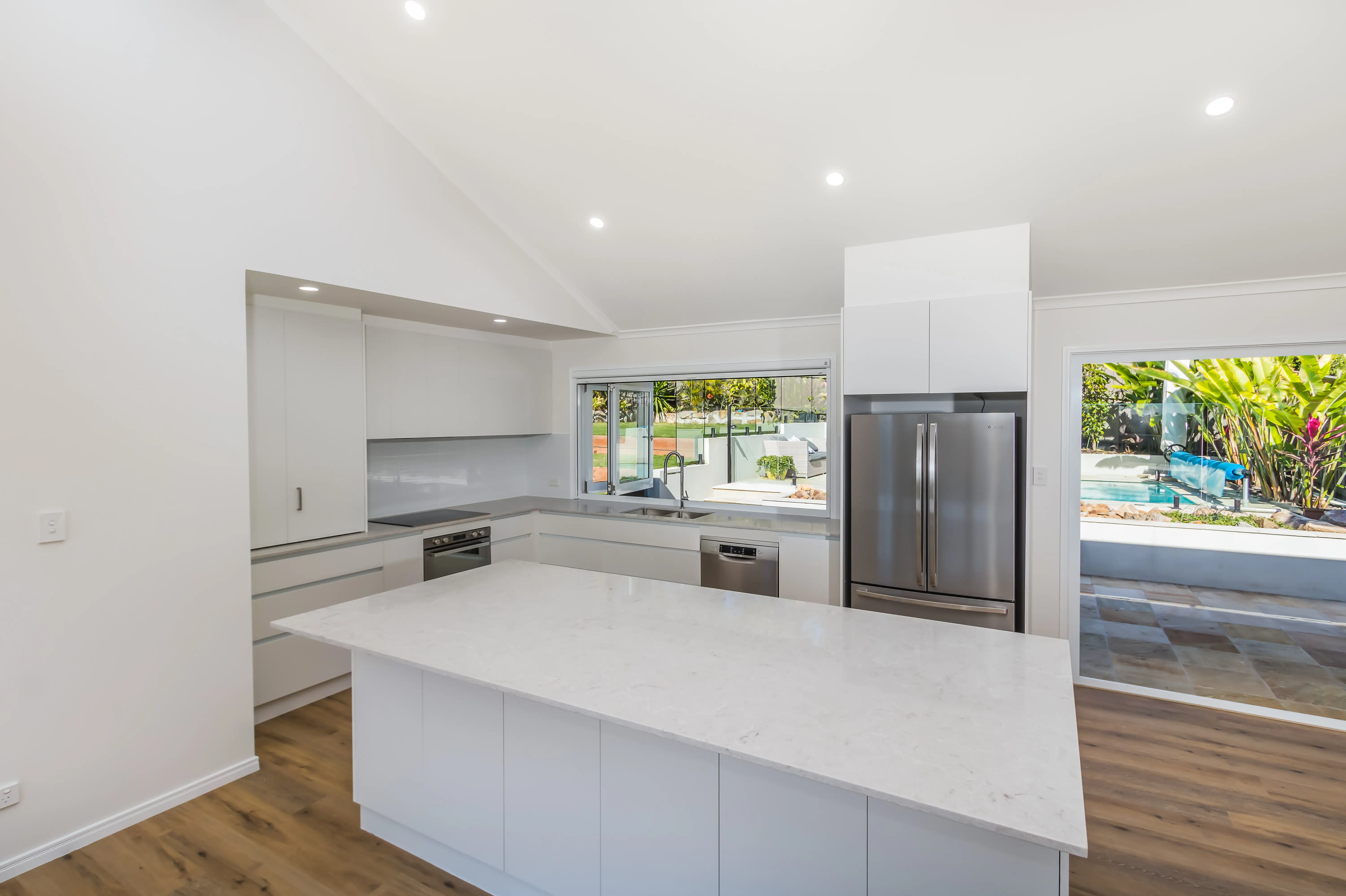 Kitchen with stone tops and finger pull cabinetry-travertine tiles