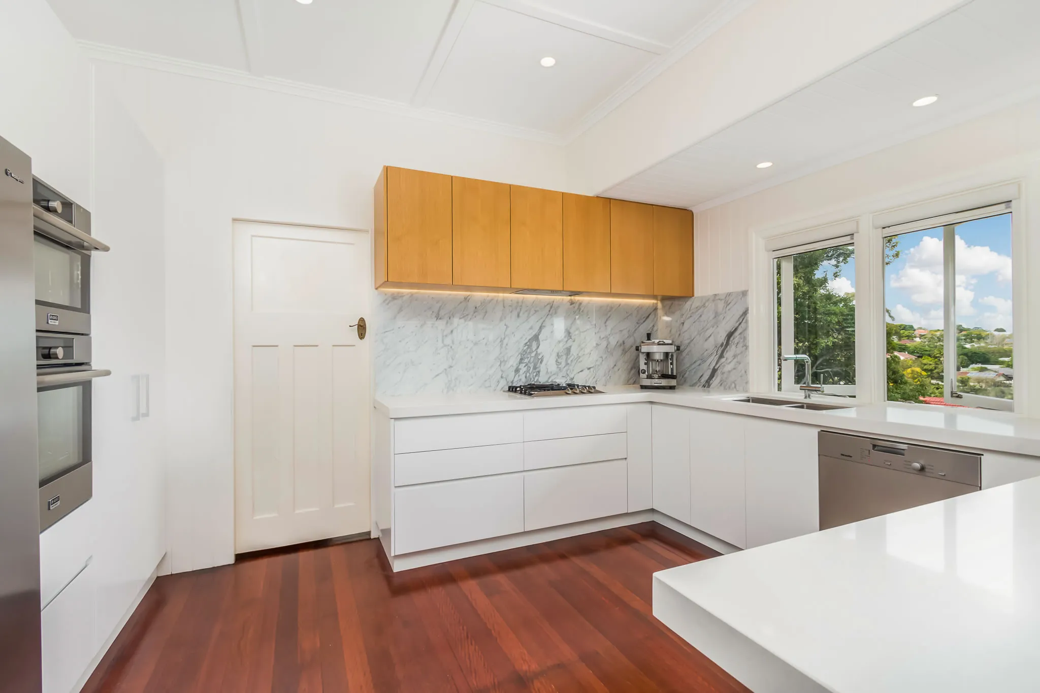 kitchen-marble splashback-white cabinetry-timber floors