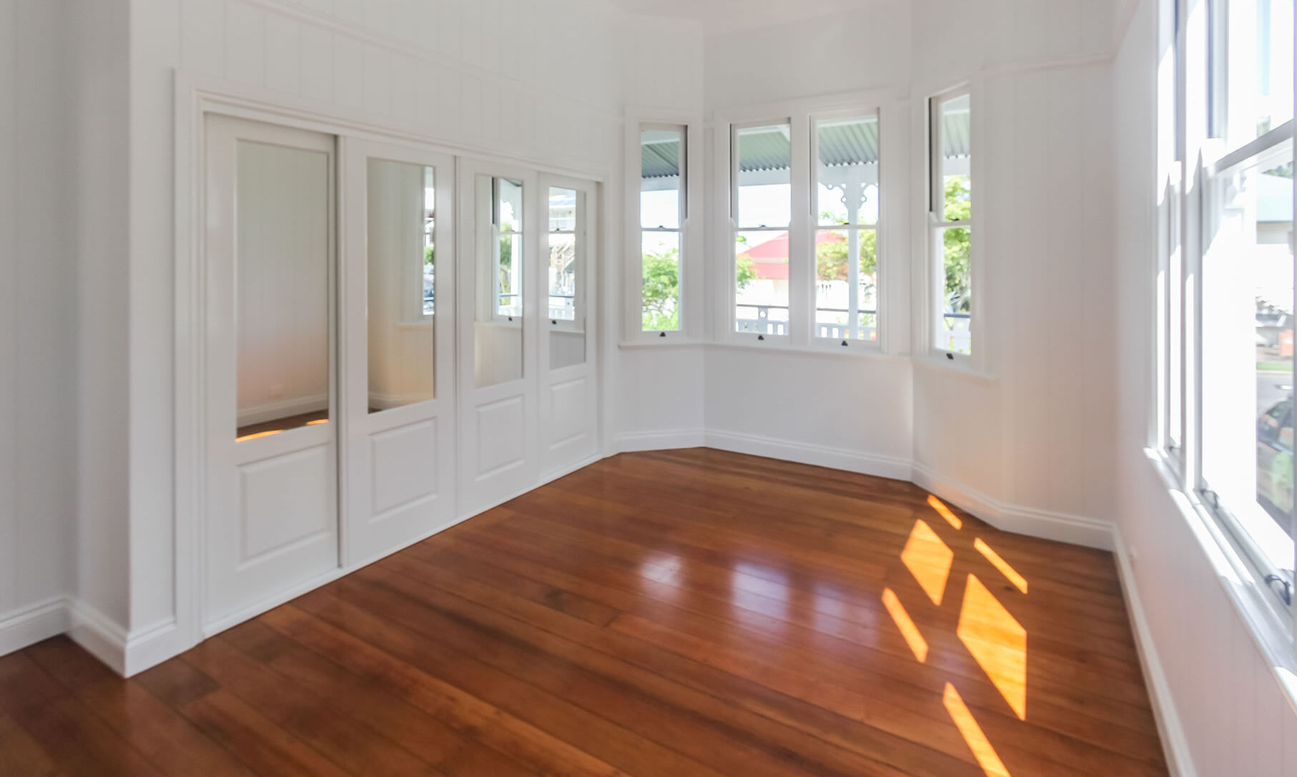 Bay window and traditional mirrored robe doors in master bedroom