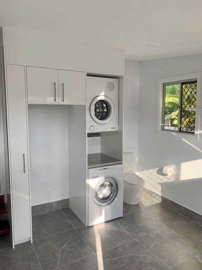 laundry renovation-floor tiles-subway tiles-white cabinets-stacking white goods