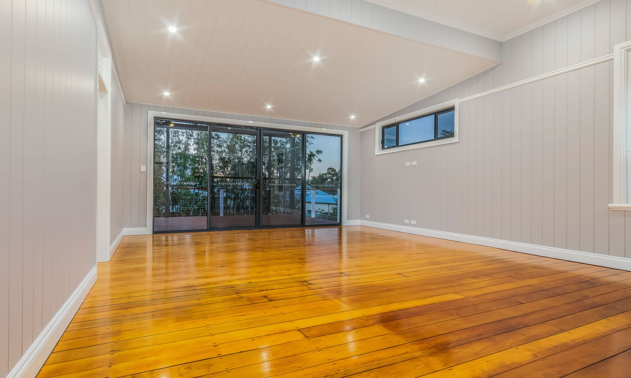 Living room with large sliding doors and wide pine flooring 