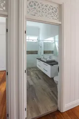 Fretwork above door in bathroom and floating vanity