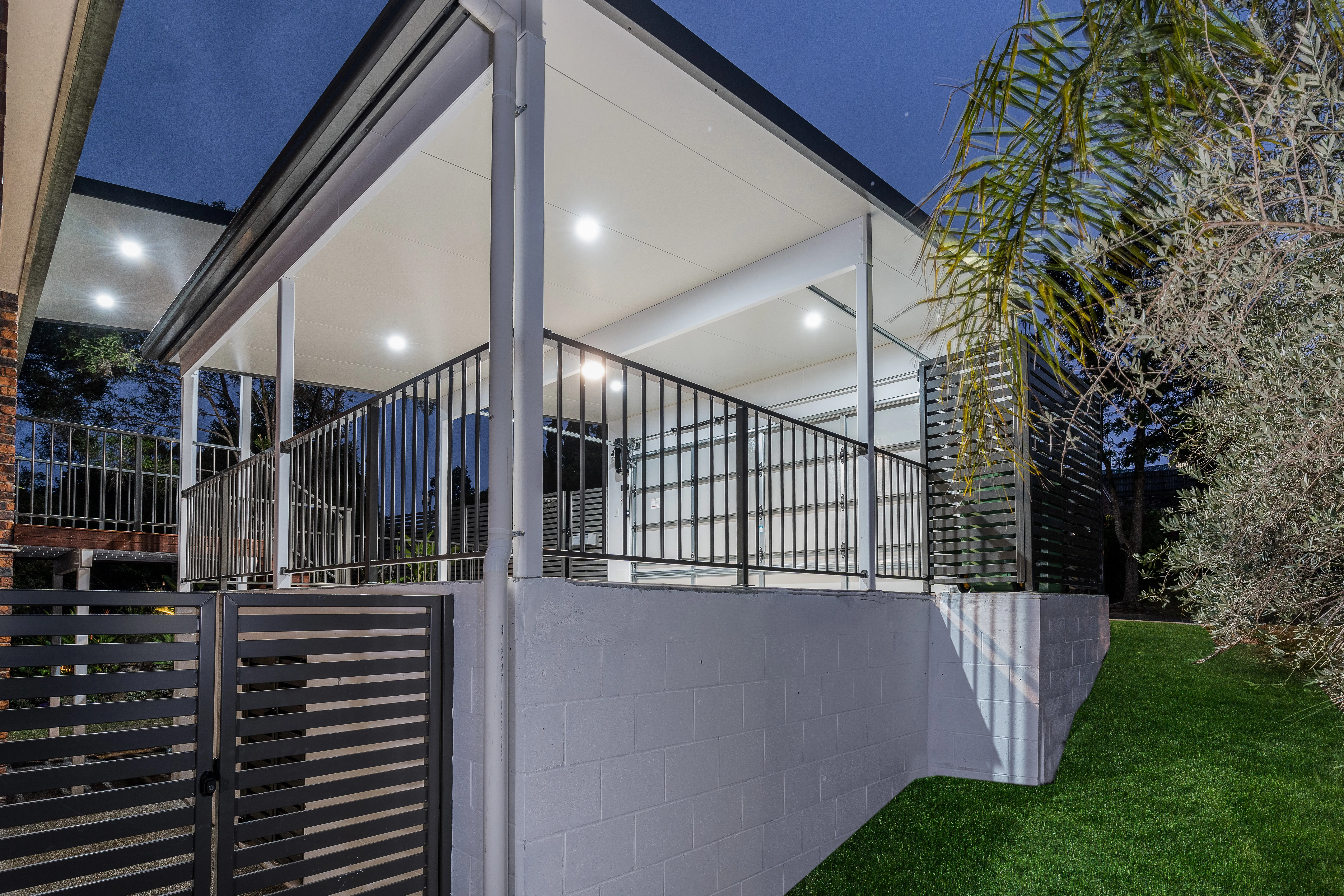Carport with garage door and balustrade with powder coated gate