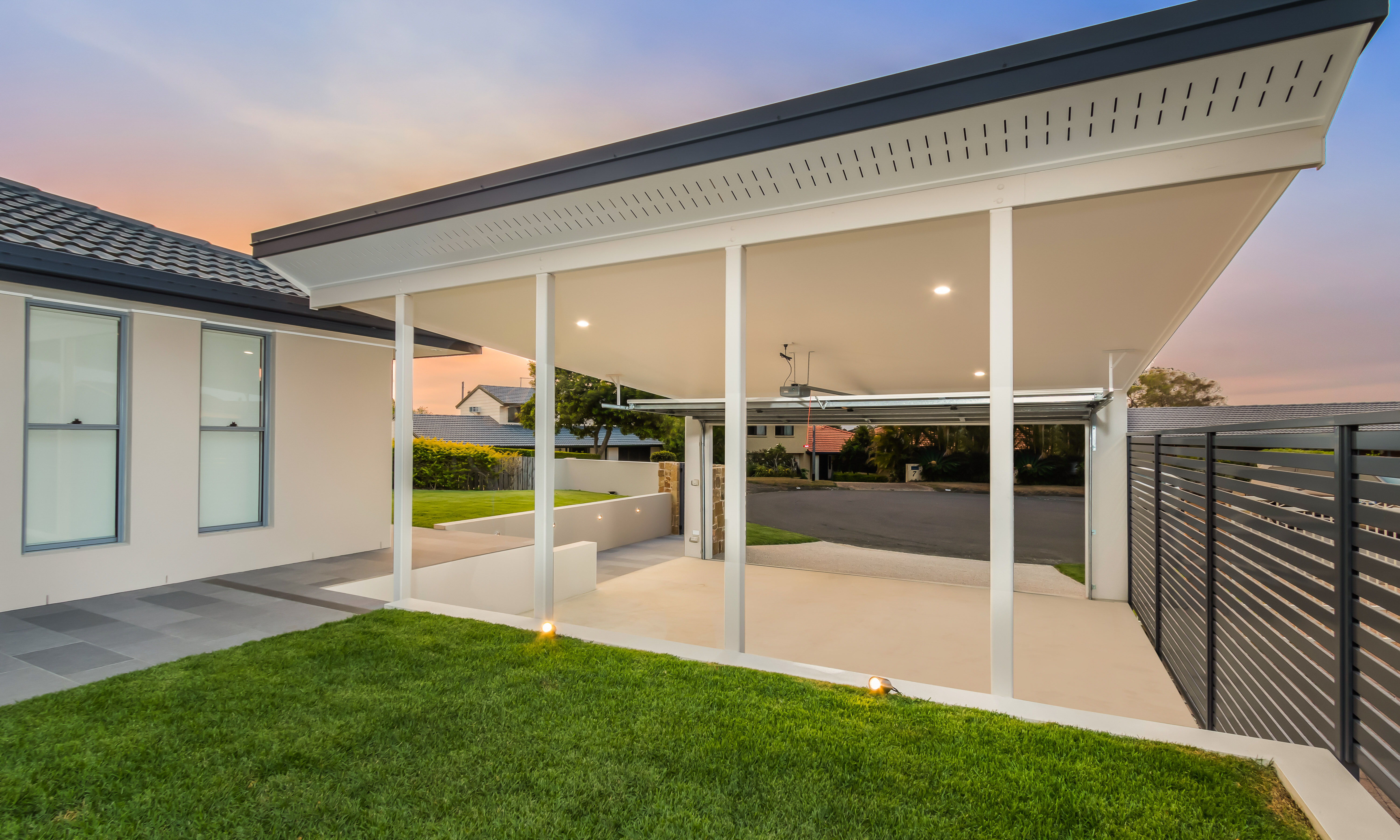 Double carport and front entry, exposed concrete driveway