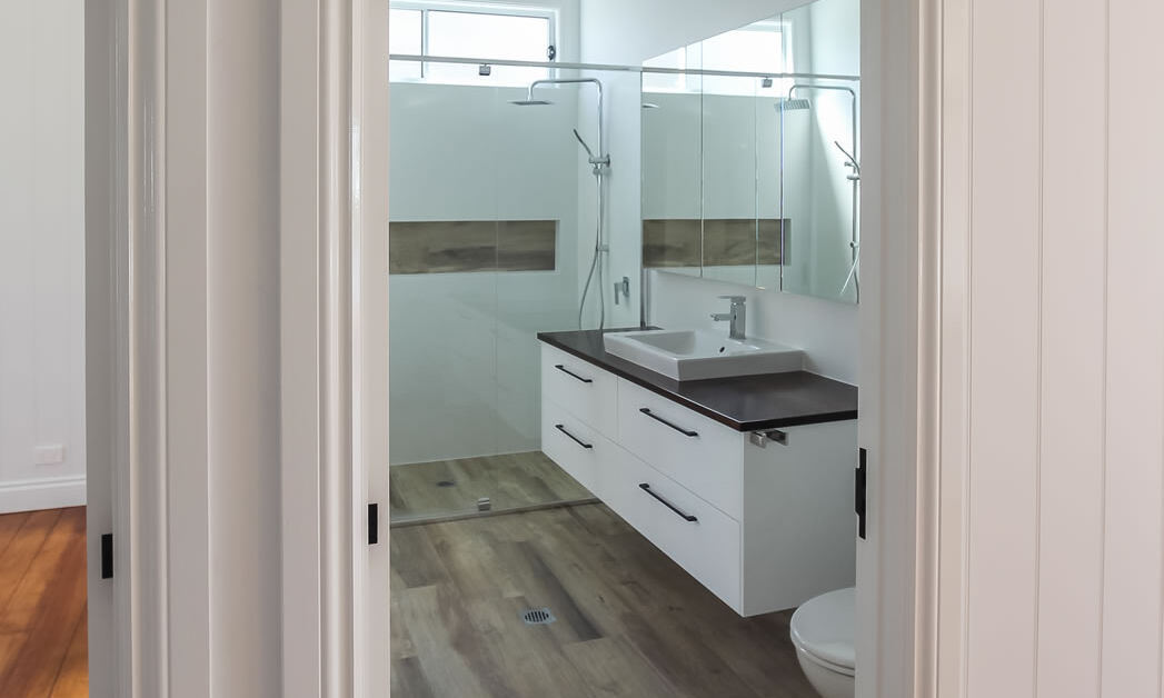 Fretwork above door in bathroom and floating vanity