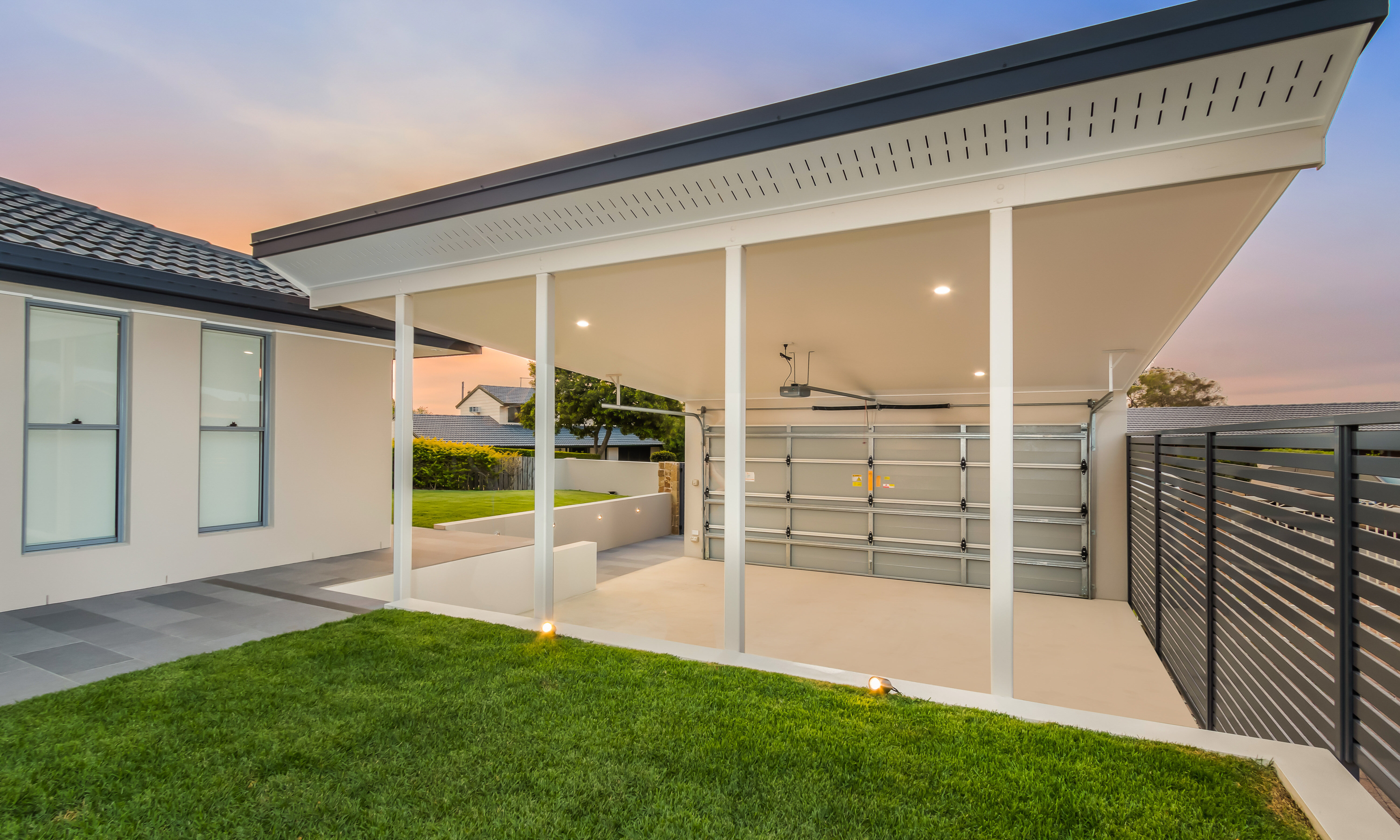 Double carport and front entry with featured tiled pathway and external lights