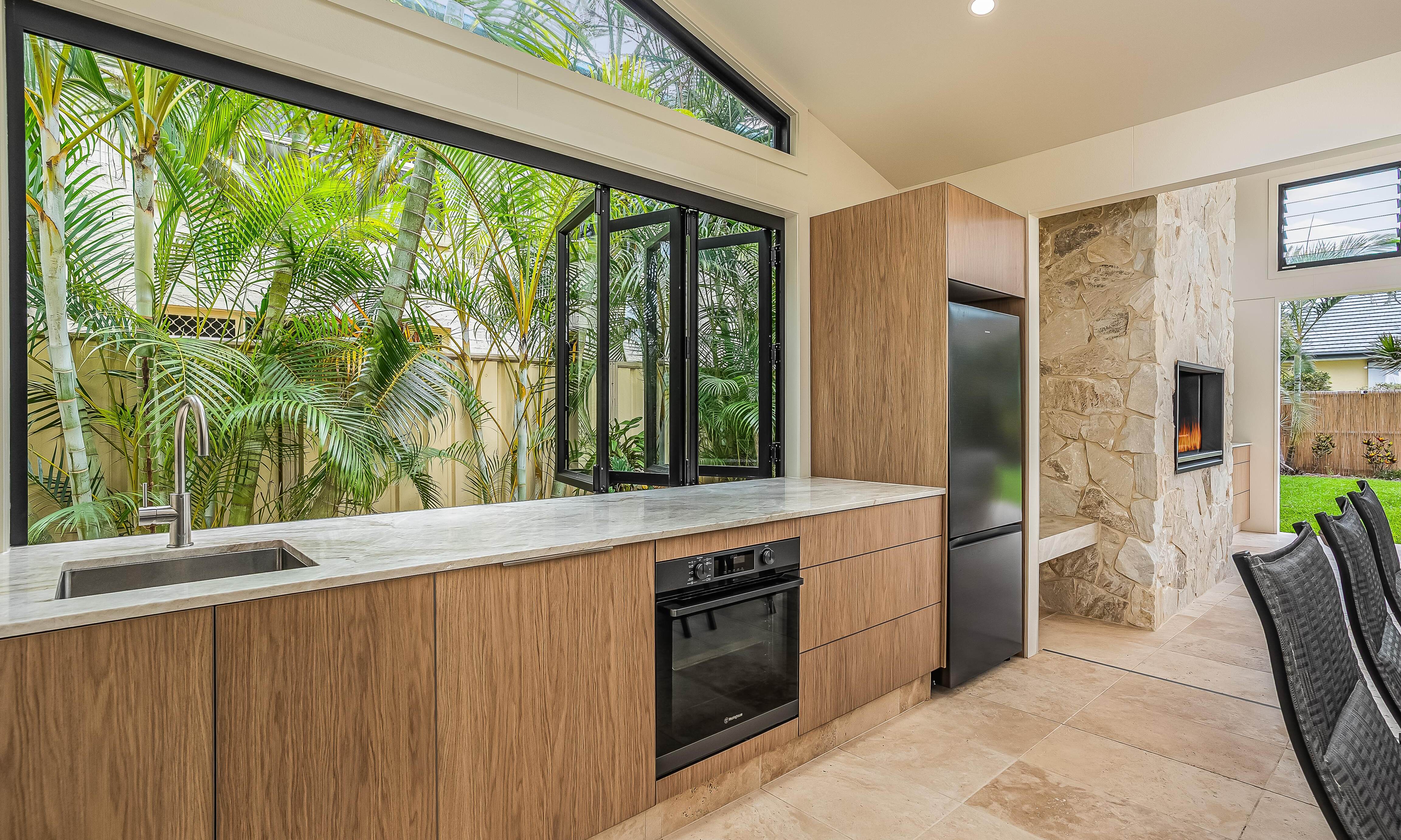 Sweetapple - Outdoor kitchen, Bifold indows, feature cladding, travertine tiles
